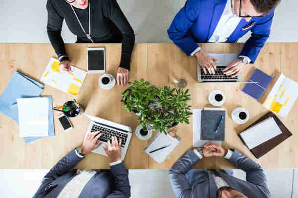 Mensen met computers zitten aan tafel